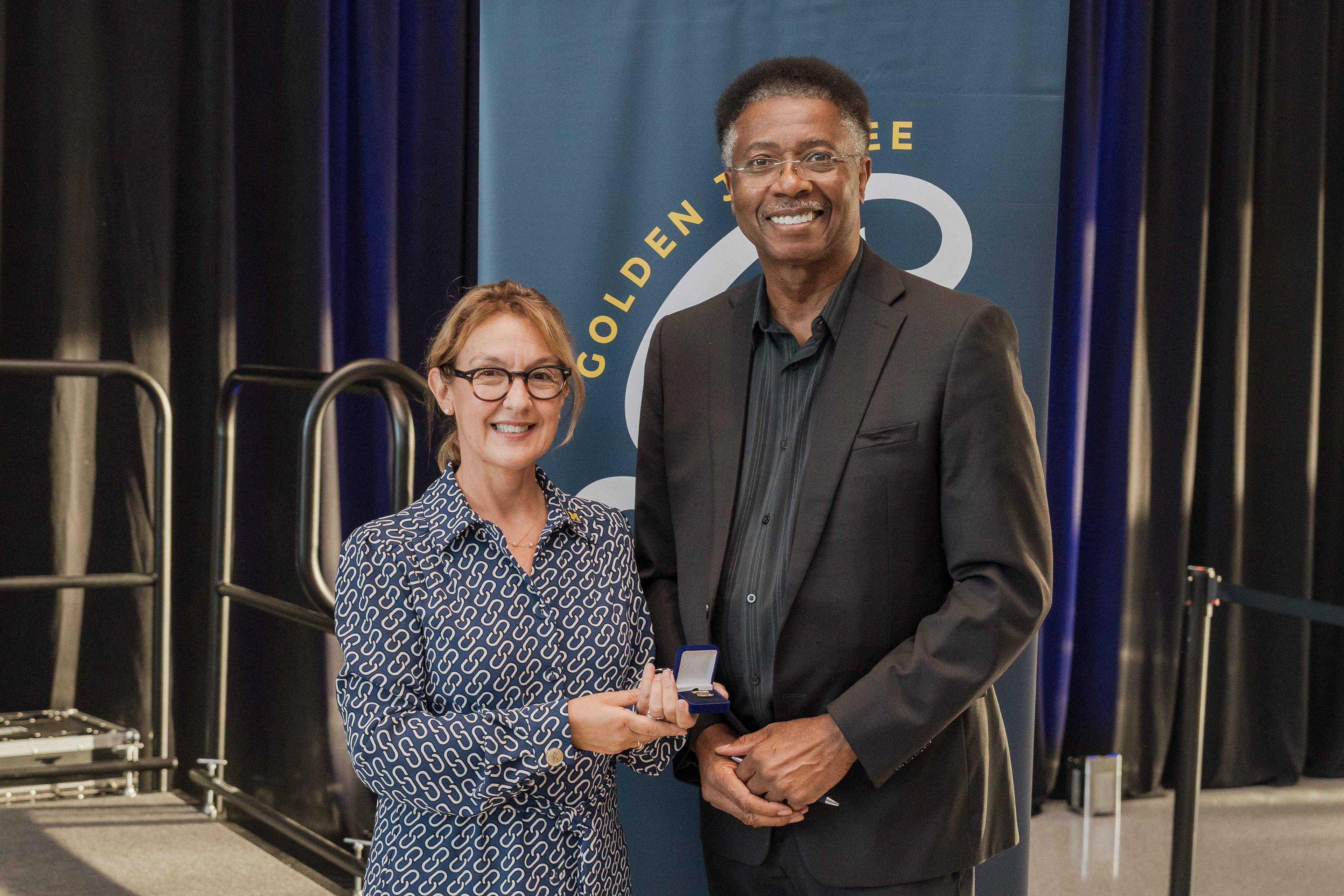 Chancellor Gabriella Scarlatta presents a Jubilee pin to 50th anniversary alumni