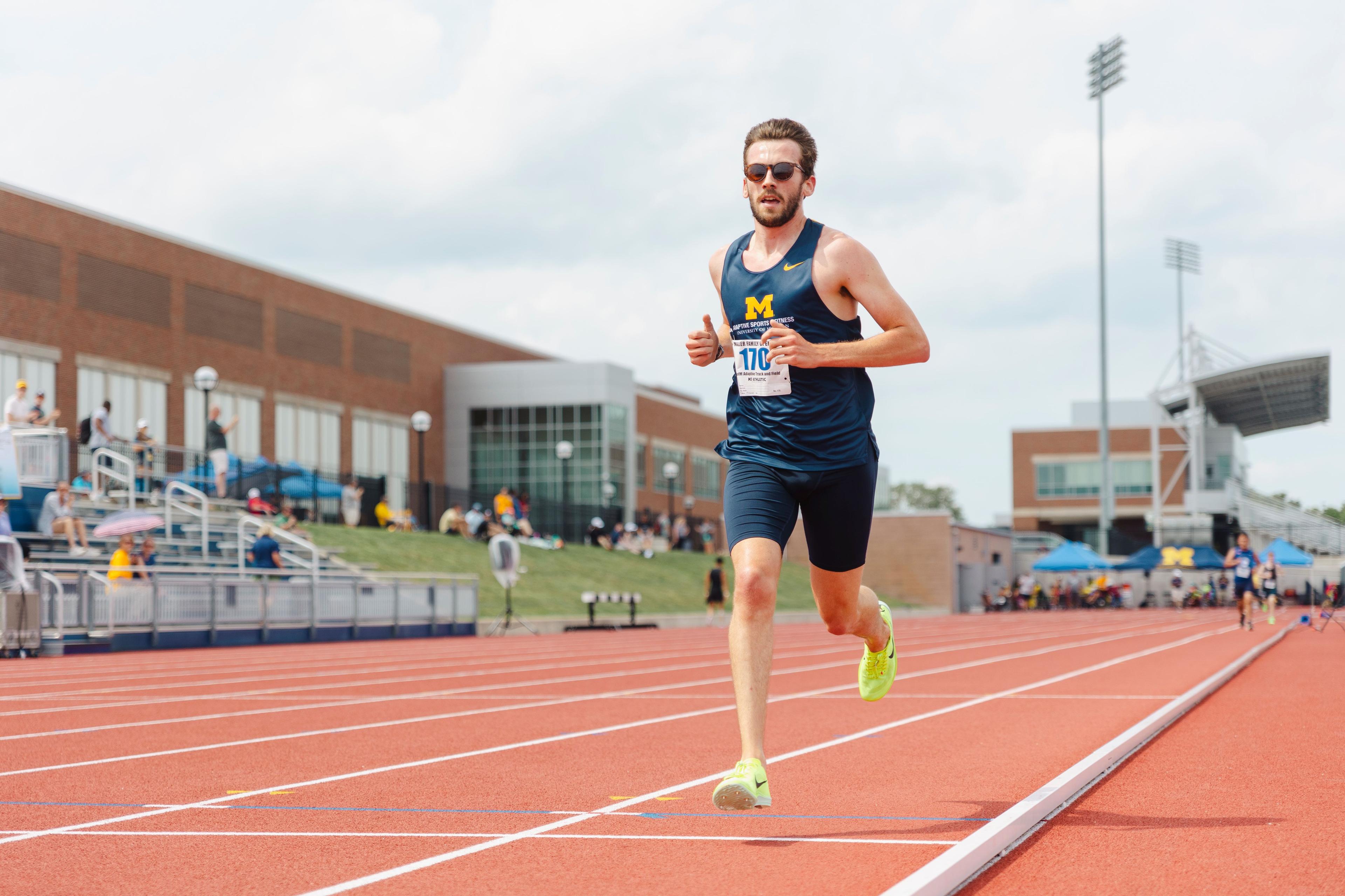 adaptive ambulatory athlete running on the inside lane of the track in the 1500M competition