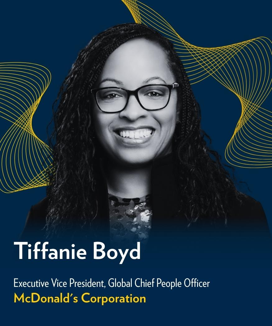 Tiffanie Boyd, Executive Vice President and Global Chief People Officer at McDonald’s Corporation, smiles against a dark blue background with maize wave graphics.